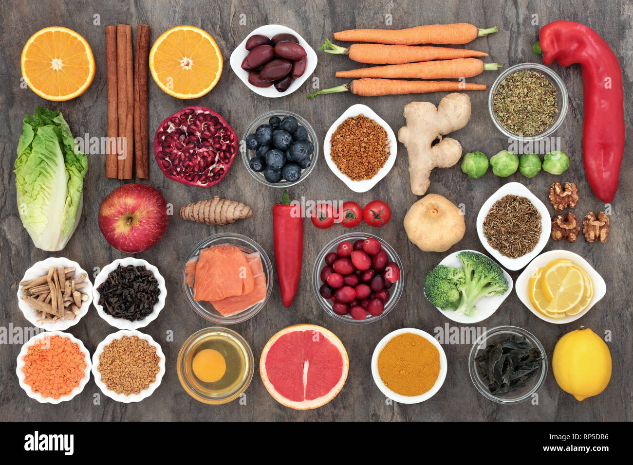 Healthy food to slow the ageing process concept including fruit, vegetables, fish, seeds, nuts, herbs, spices and pollen grain. Stock Photo