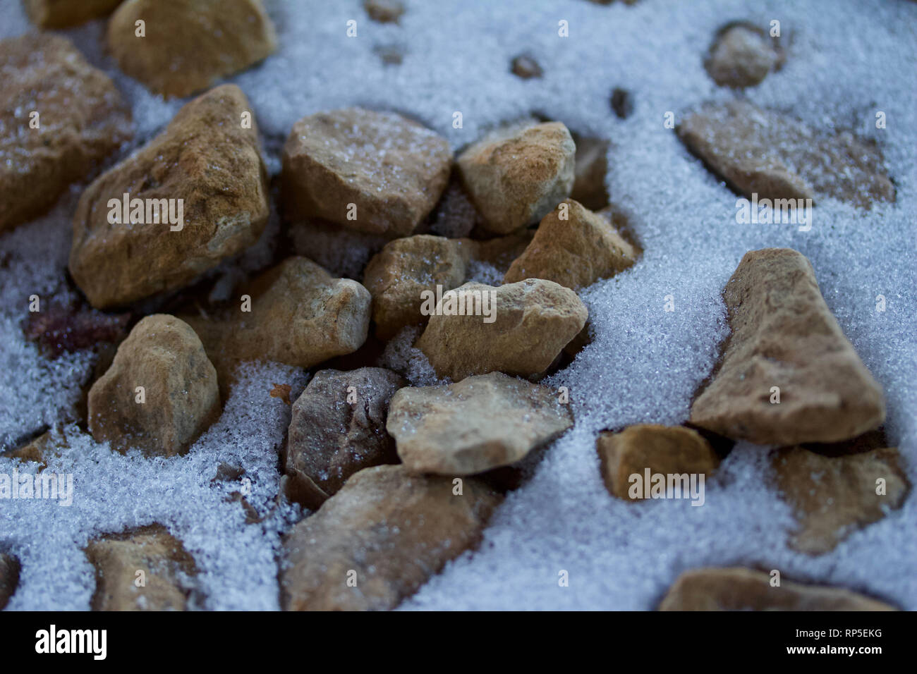 Macro abstract background image of partially snow covered brown rocks ...