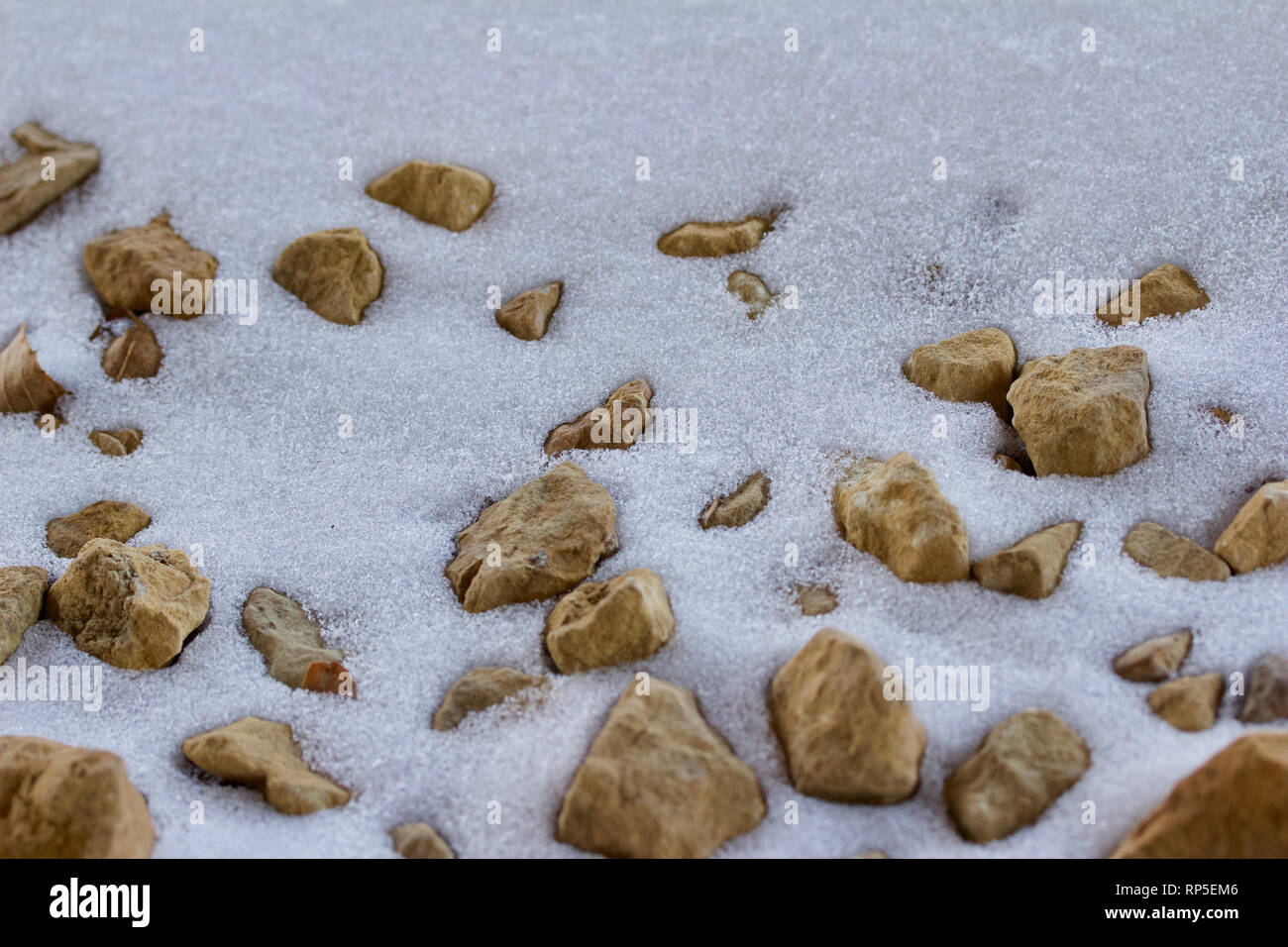 Macro abstract background image of partially snow covered brown rocks ...
