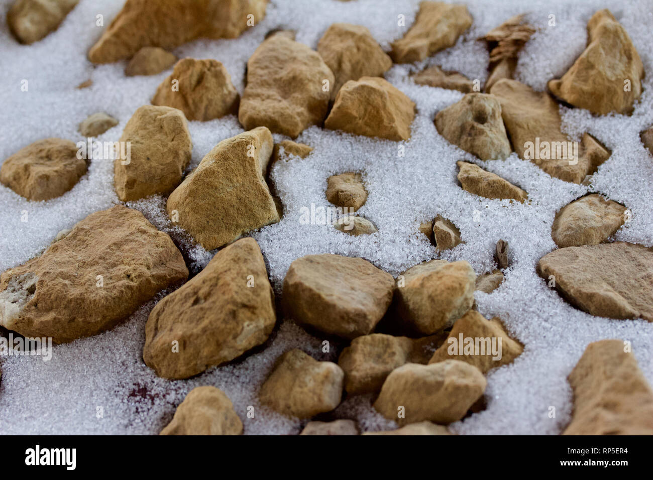 Macro abstract background image of partially snow covered brown rocks ...