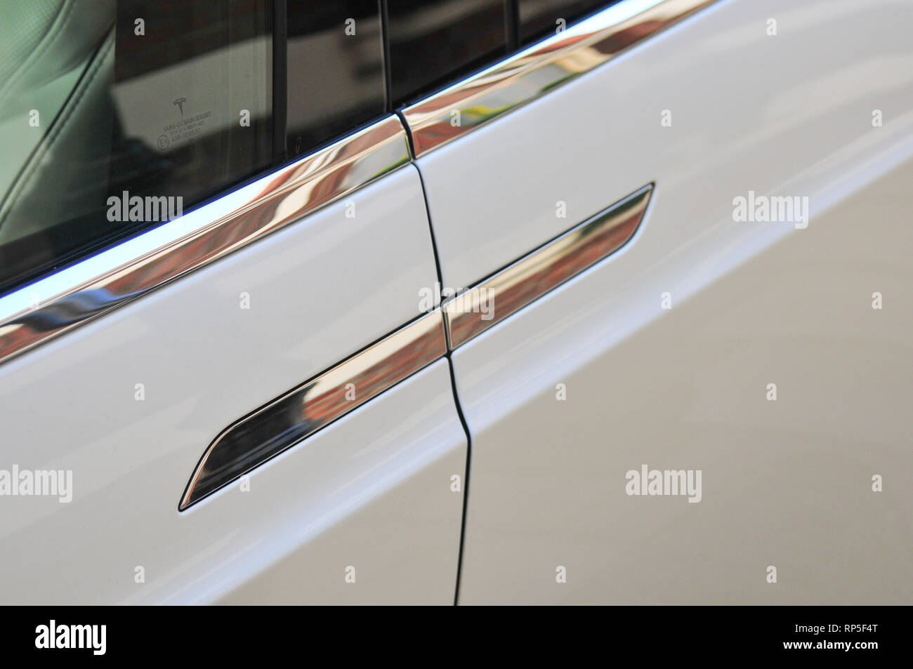 A detailed photograph of a door handle on a white Tesla Model X ...