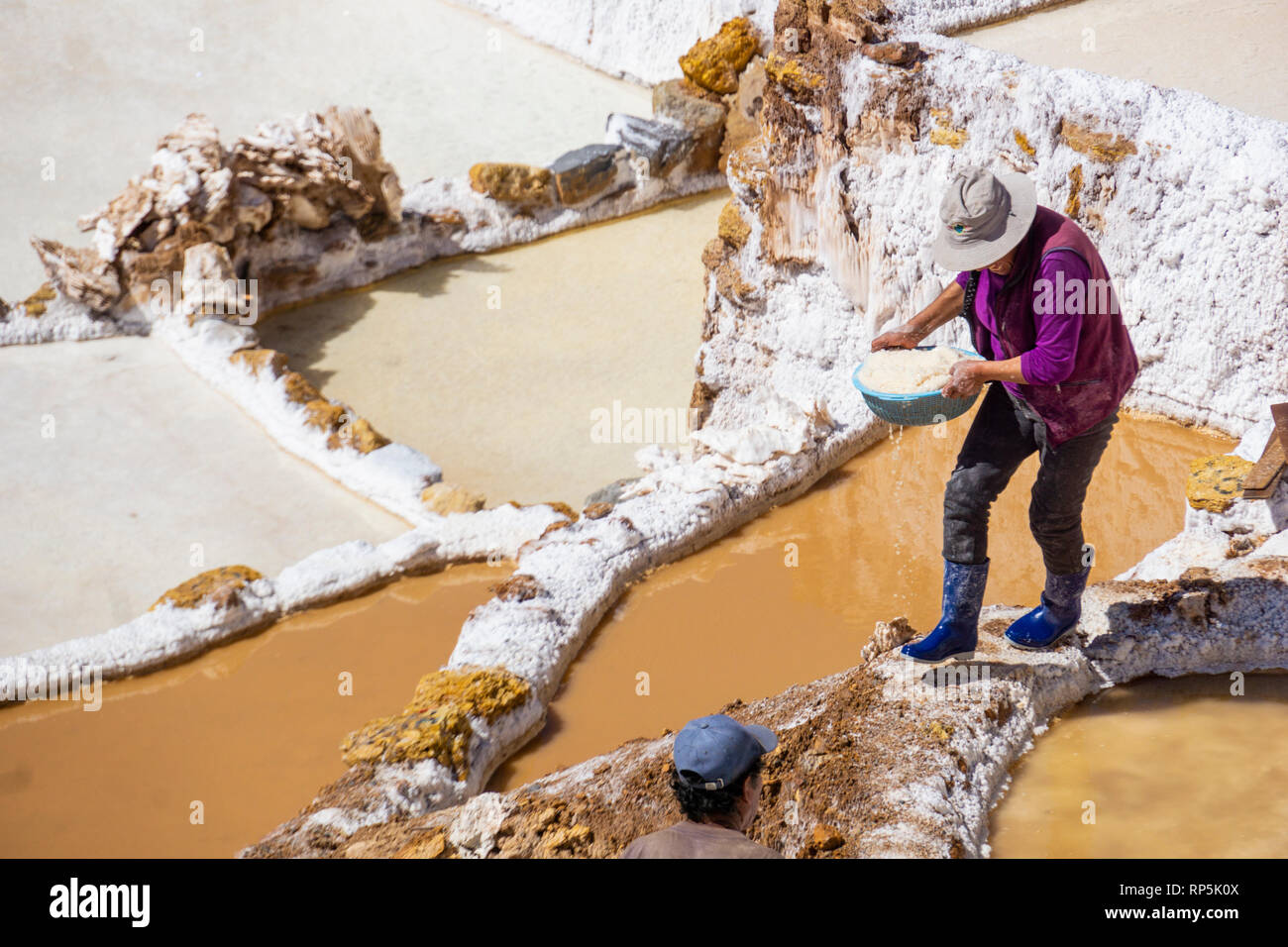 Workers in Maras salt mines on the hillside in the mountainous Cuzco region of Peru. Stock Photo