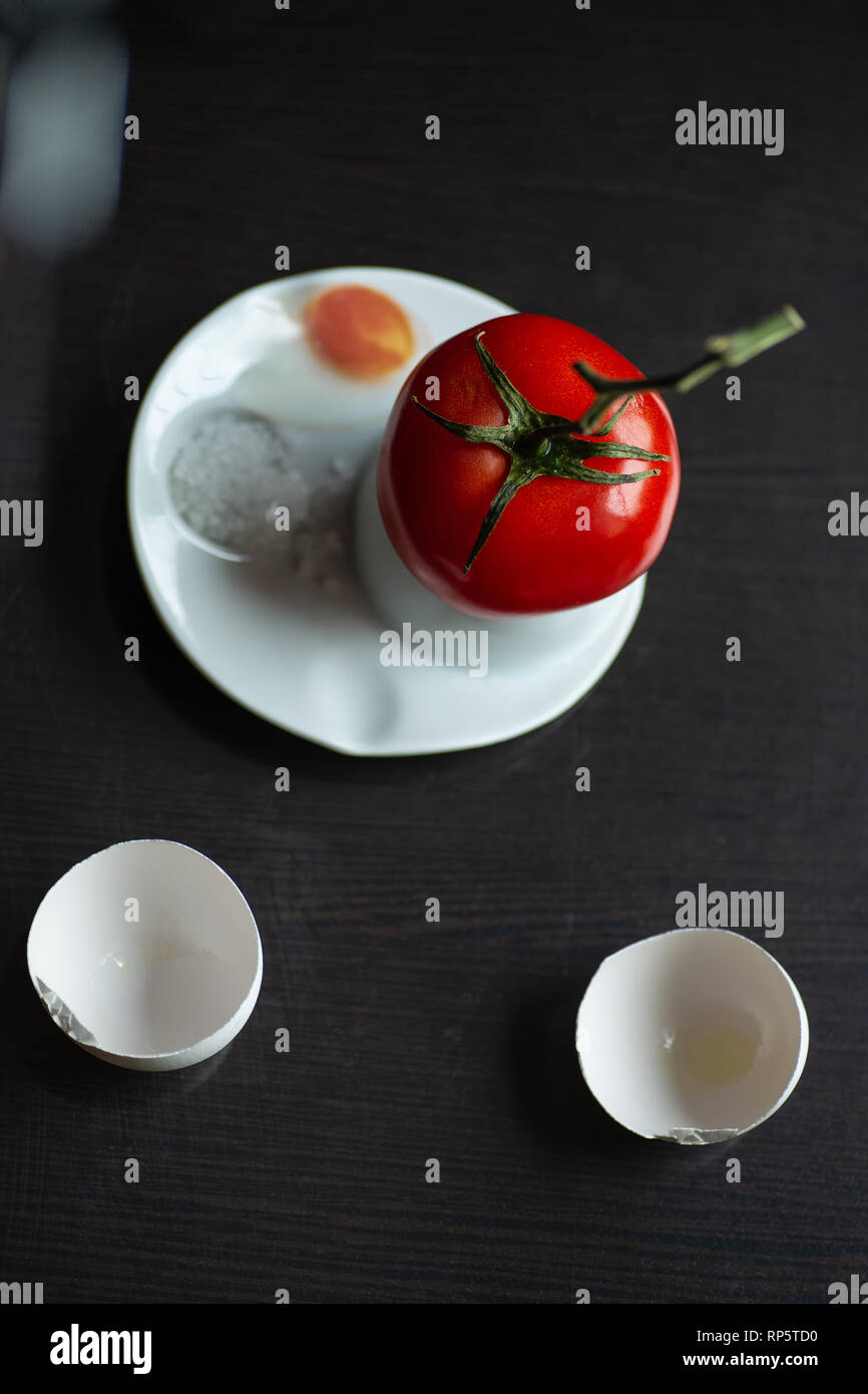 a bright red tomato on a branch hatched from an egg Stock Photo