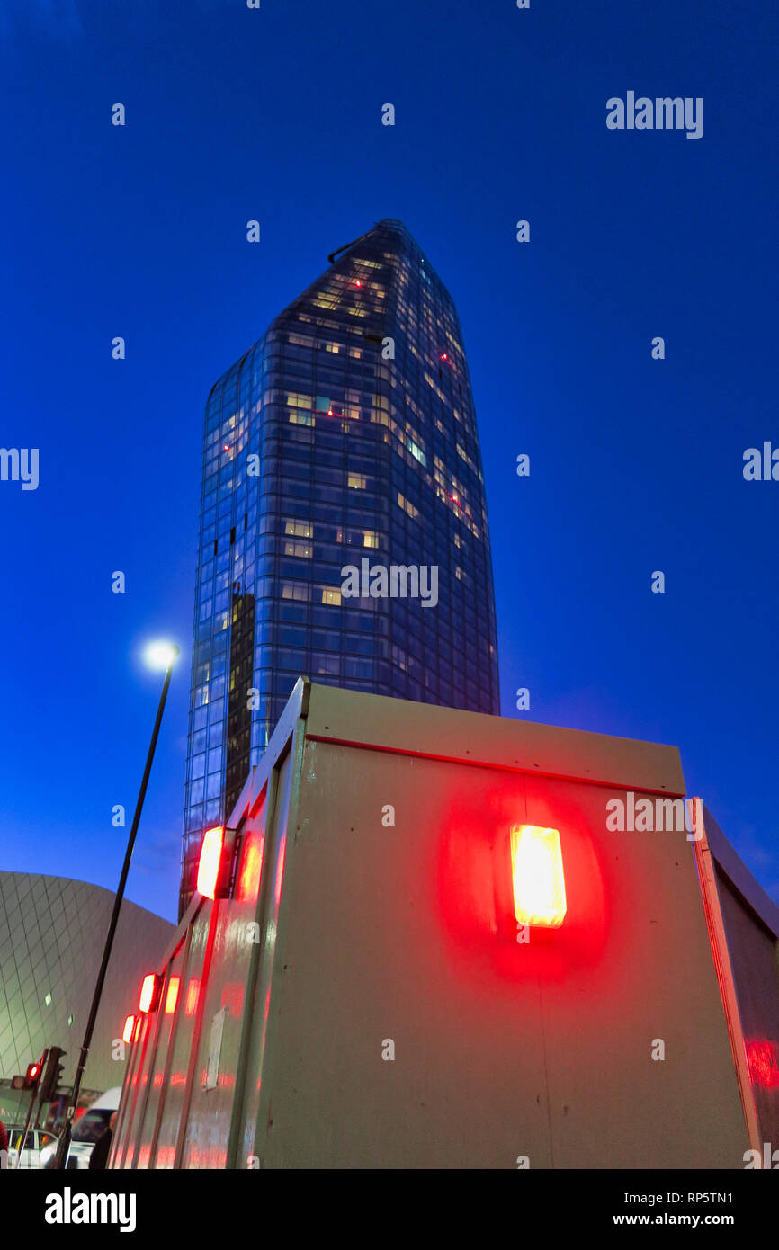 Red lights around construction site with modern skyscraper building in