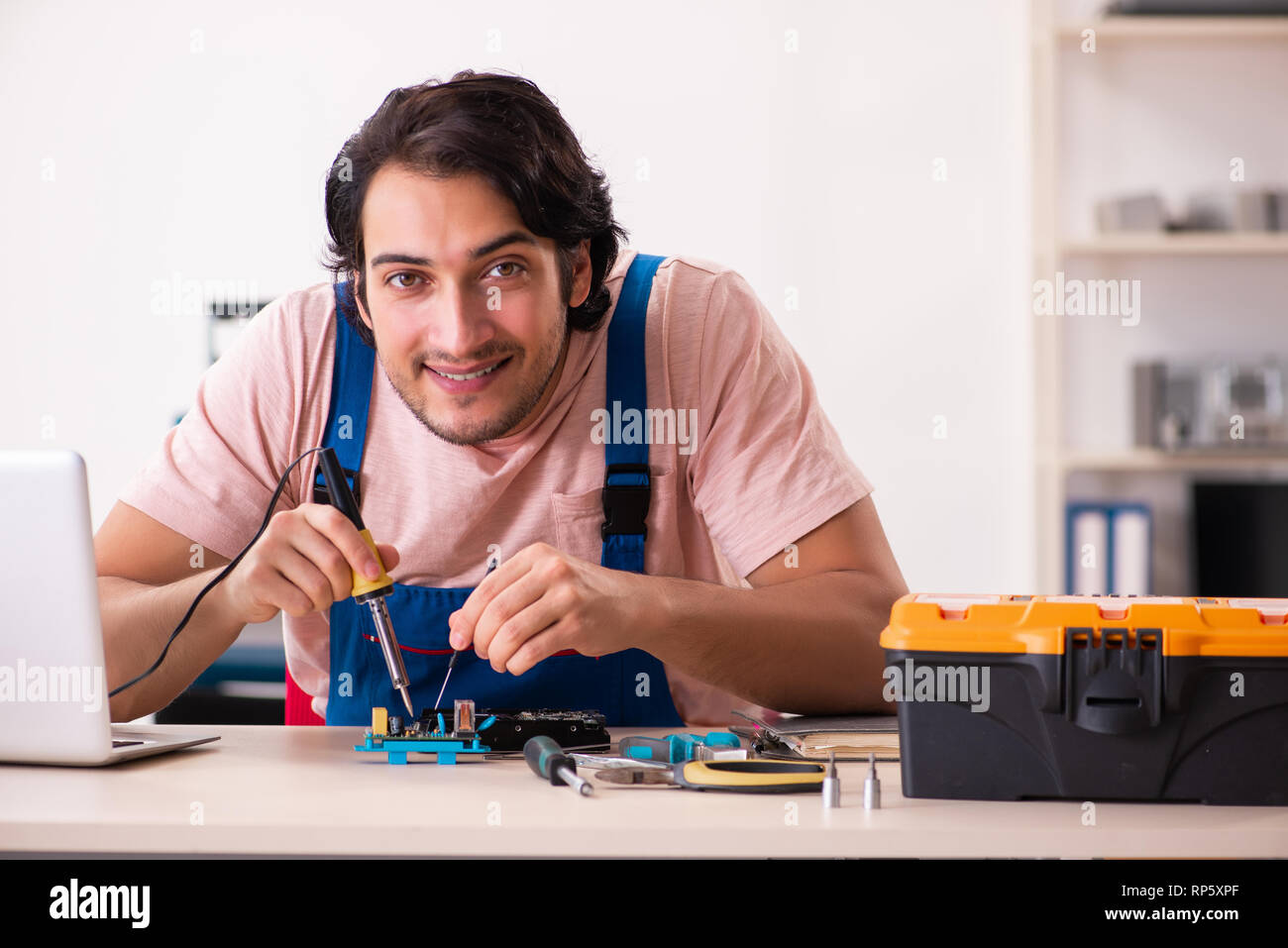 Young male contractor repairing computer Stock Photo