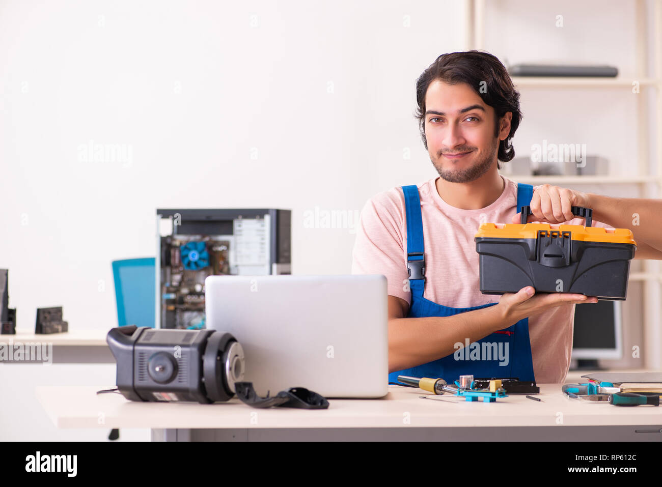 Young male contractor repairing computer Stock Photo