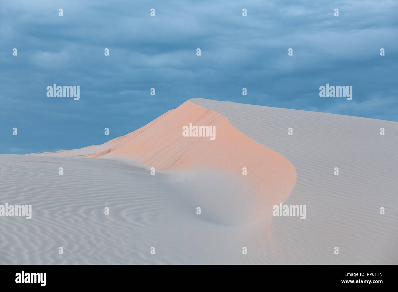 Beautiful white sand dune under cloudy sunset skies. Anna Bay, New South Wales, Australia Stock Photo