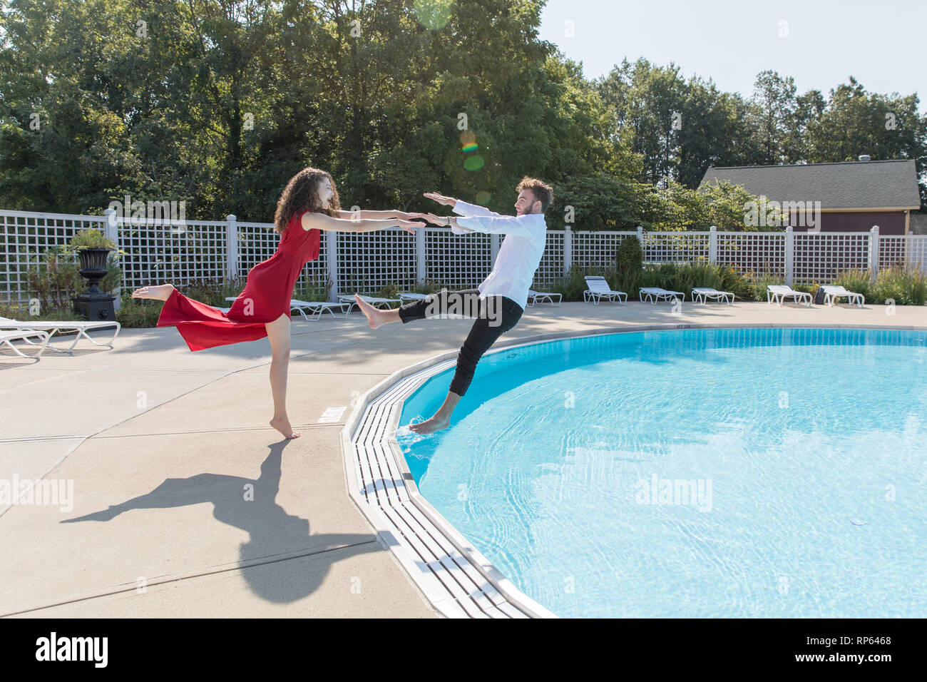 A young couple goofing around by a pool Stock Photo