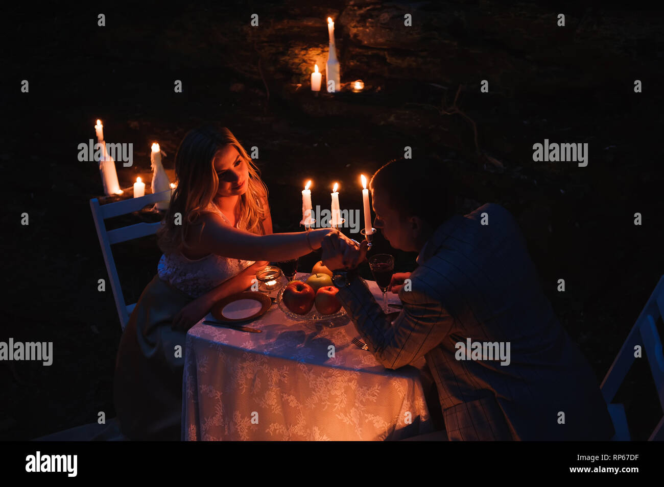 Romantic couple holding hands together over candlelight Stock Photo Alamy