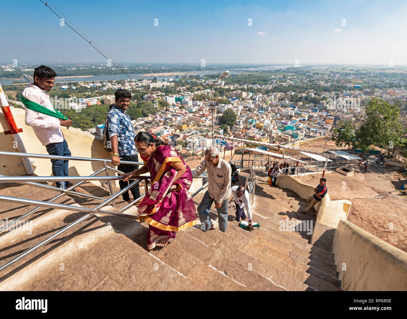 A cityscape view taken from the Rock Fort Temple in Tiruchirappalli or Trichy showing people climbing stairs to the temple. Stock Photo