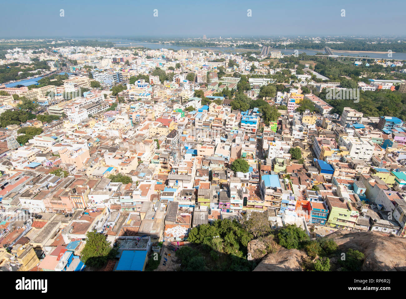 A cityscape view over Tiruchirappalli or Trichy in India taken from the Rock Fort Temple on a sunny day with blue sky. Stock Photo