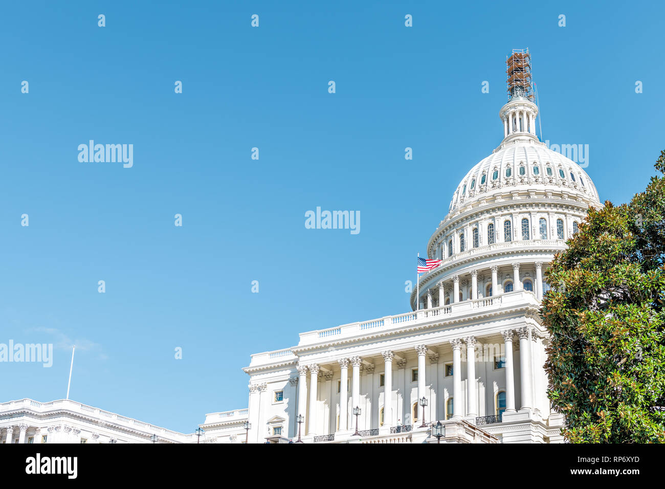 Washington DC, USA US Congress dome construction exterior with steps stairs view and flag on Capital capitol hill with blue sky columns pillars and sc Stock Photo