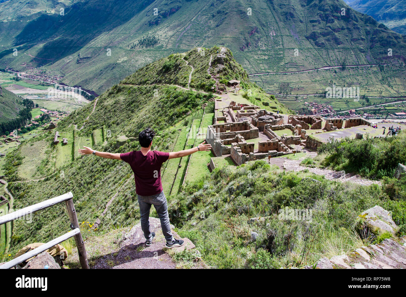 Tourist exploring the Inca Trails leading to the ruins of Pisac, Sacred Valley, major travel destination in Cusco region, Peru. Vacations and adventures in South America. Stock Photo