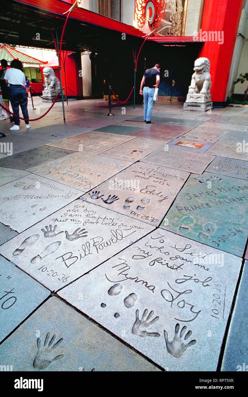 The handprints, footprints and autographs of famous celebrities have been cast in concrete in the Forecourt of the Stars since 1927 at the Chinese Theatre in Hollywood, California, USA. Long known as Grauman's Chinese Theatre, it was later called Mann's Chinese Theatre and is now named the TLC Chinese Theatre. Impressions in the foreground were made in 1936 by two movie stars who appeared in 14 films together, William Powell and Myrna Loy. They are among early signees who inscribed personal messages to Sid Grauman, the man who built the lavish movie house and managed it until his death in 1950 Stock Photo