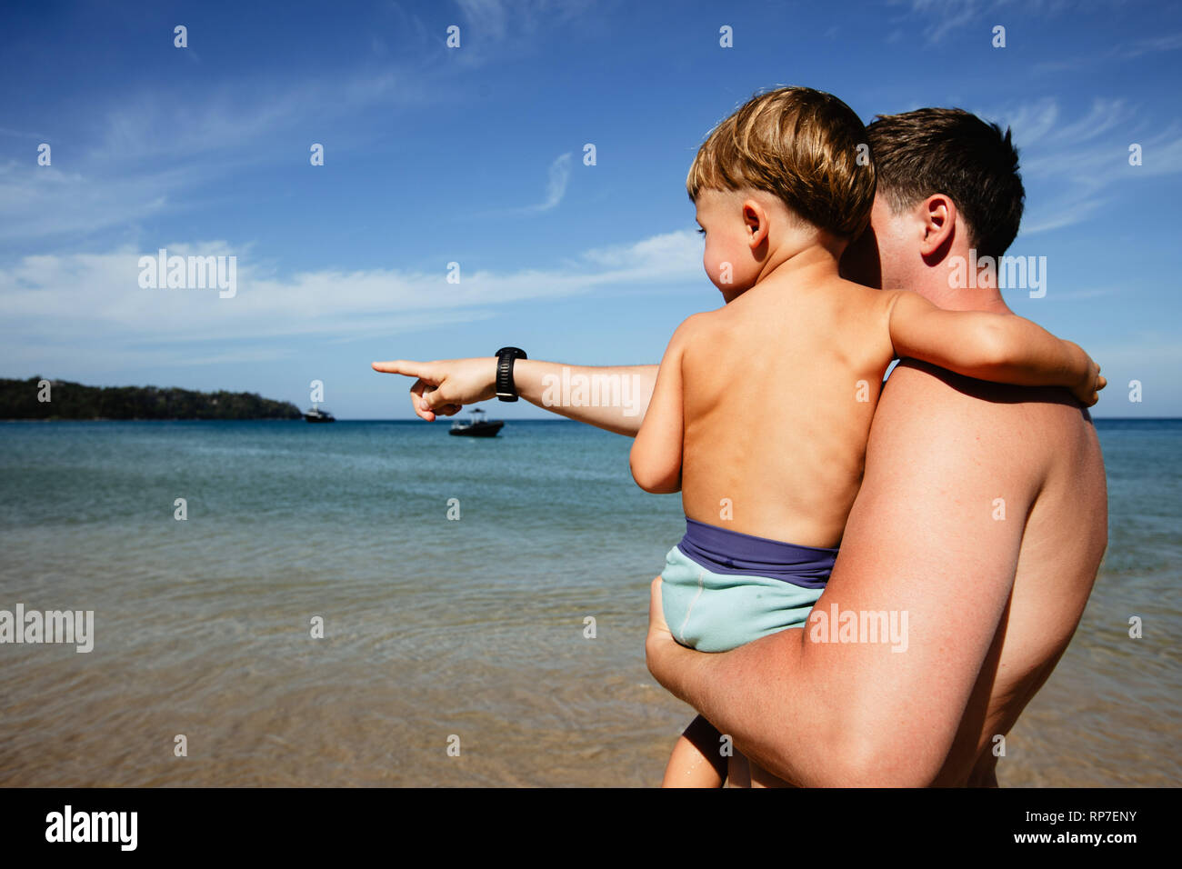 Man with boy exploring seashore Stock Photo