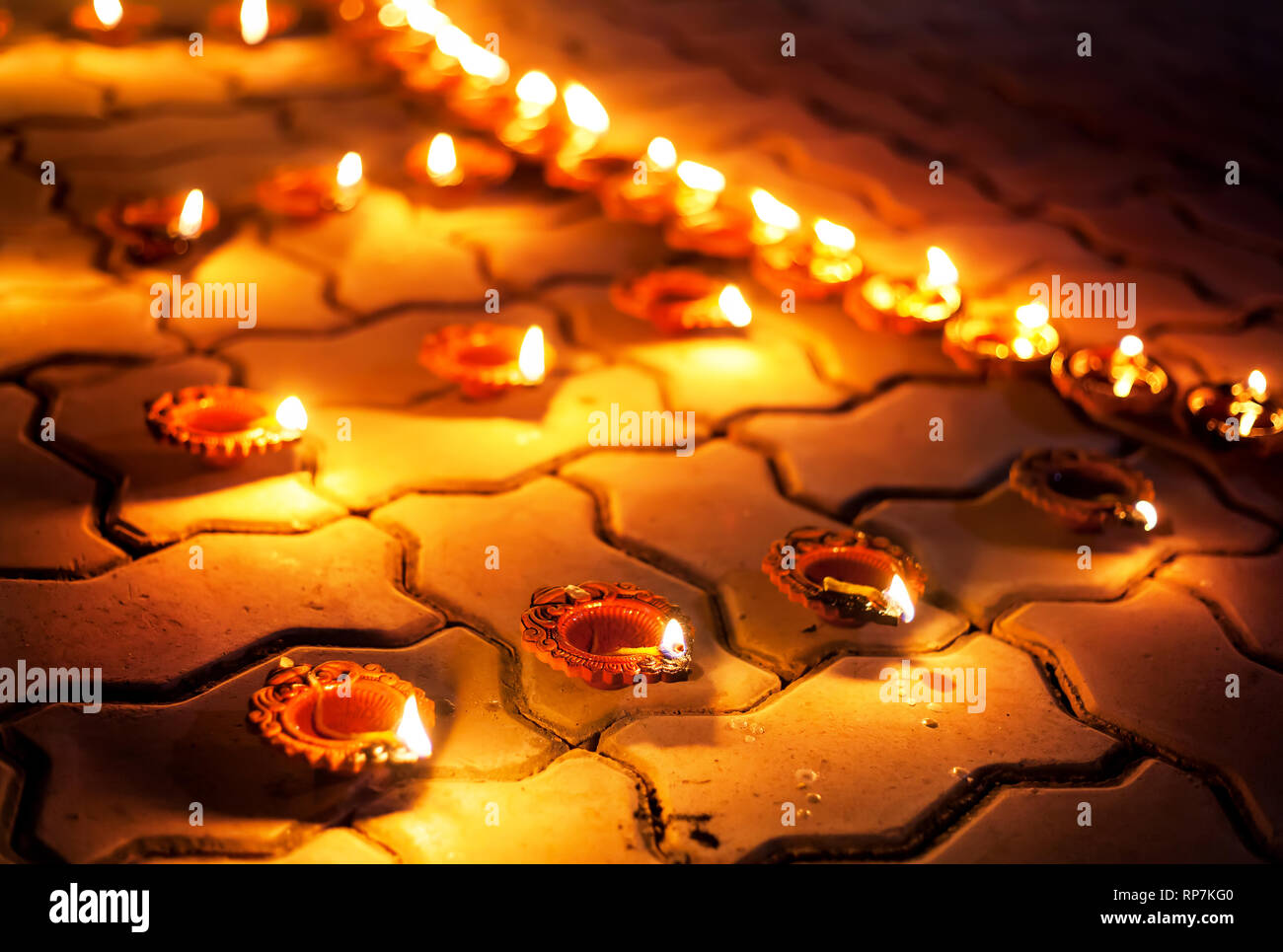Traditional clay diya lamps lit on the ground during festival diwali celebration Stock Photo