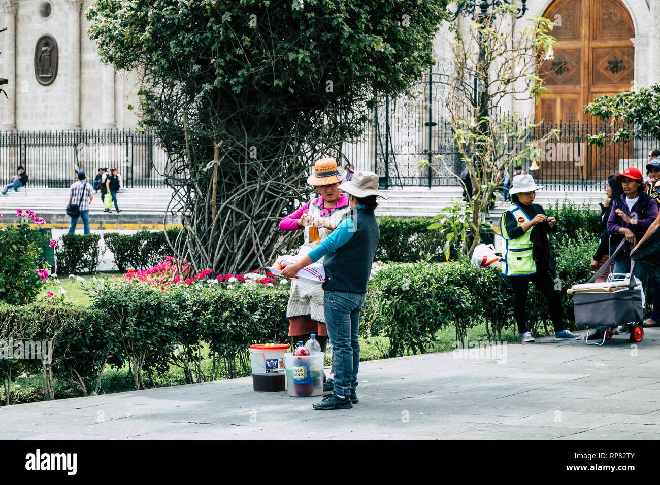 Two street vendors are having a conversation in the main park of Arequipa (Peru). Stock Photo