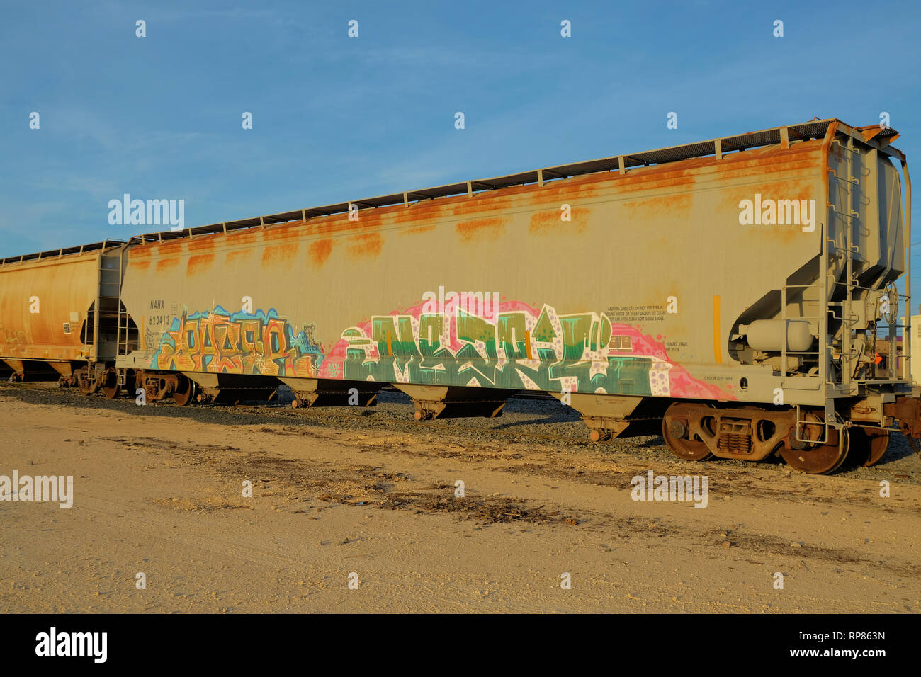 Covered hopper railway car parked on train tracks in Bryan, Texas, USA; graffiti on the side of a train car. Stock Photo