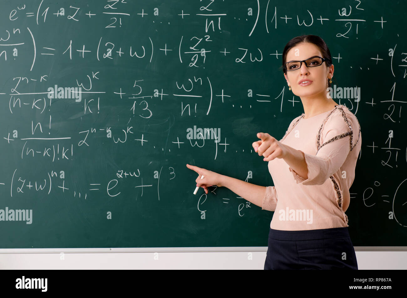 Female teacher standing in front of chalkboard Stock Photo - Alamy