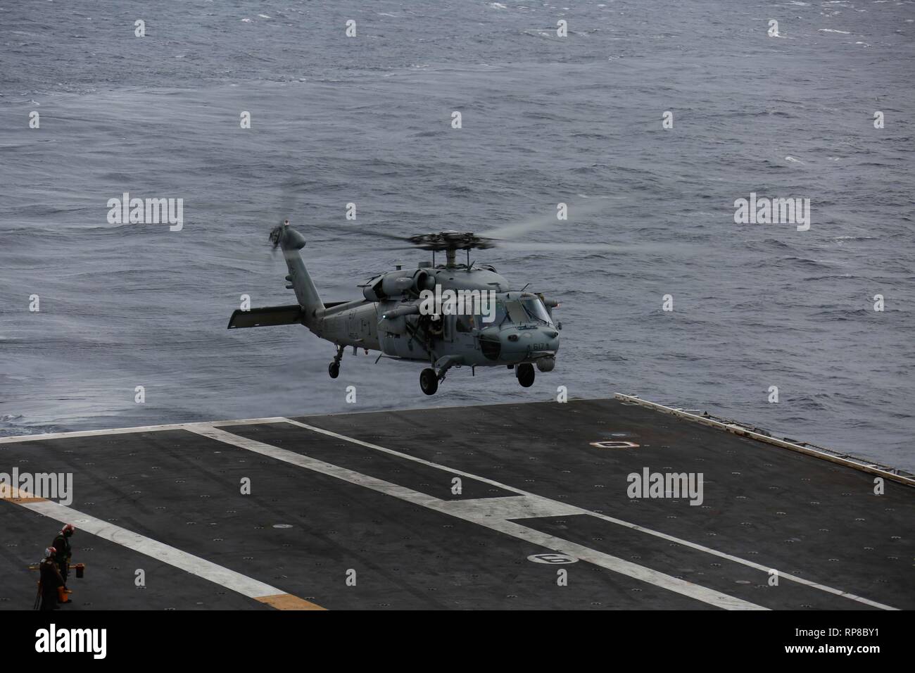 190219-N-MM912-1055 ATLANTIC OCEAN (Feb. 19, 2019) An MH-60S Sea Hawk Helicopter assigned to the "Nightdippers" of Helicopter Sea Combat  Squadron (HSC) 5 prepares to land on the flight deck of the Nimitz-class aircraft carrier USS Abraham Lincoln (CVN 72). Abraham Lincoln is underway conducting composite training unit exercise (COMPTUEX) with Carrier Strike Group (CSG) 12. The components of CSG 12 embody a team-of-teams concept, combining advanced surface, air and systems assets to create and sustain operational capability. This enables them to prepare for and conduct global operations, have  Stock Photo