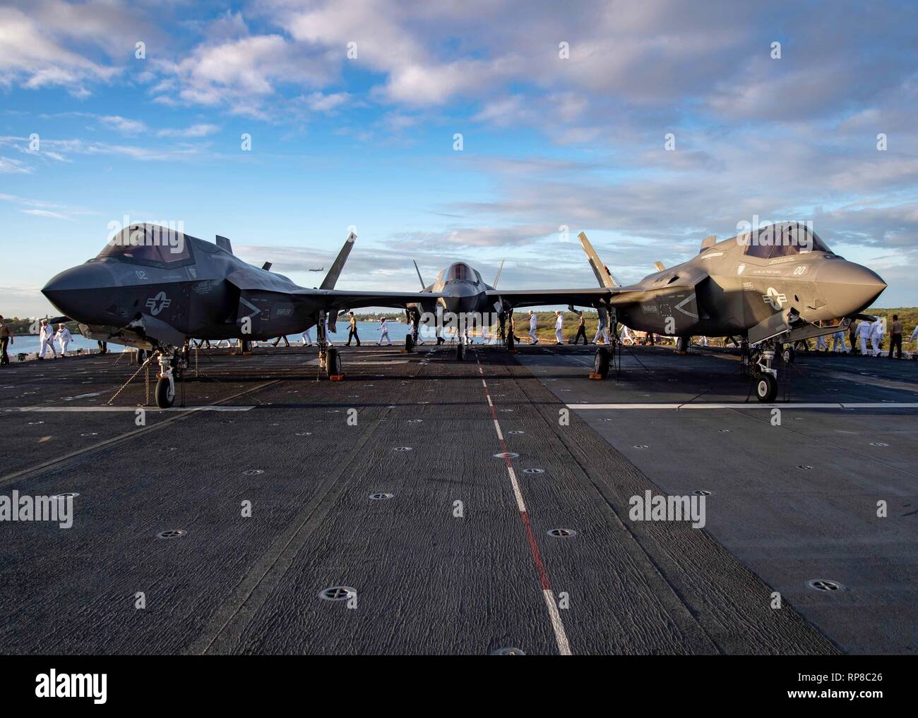 PEARL HARBOR (Feb. 18, 2019) F-35B Lightning II sit on the flight deck while Sailors and Marines prepare to man the rails of Wasp-class amphibious assault ship USS Essex (LHD 2) as it pulls into Pearl Harbor during a deployment of Essex Amphibious Ready Group (ARG) and 13th Marine Expeditionary Unit (MEU). The Essex ARG/MEU team is a strong and flexible force equipped and scalable to respond to any crisis ranging from humanitarian assistance and disaster relief to contingency operations. The Essex ARG and 13th MEU is the first continental United States Navy/Marine Corps team to deploy with the Stock Photo