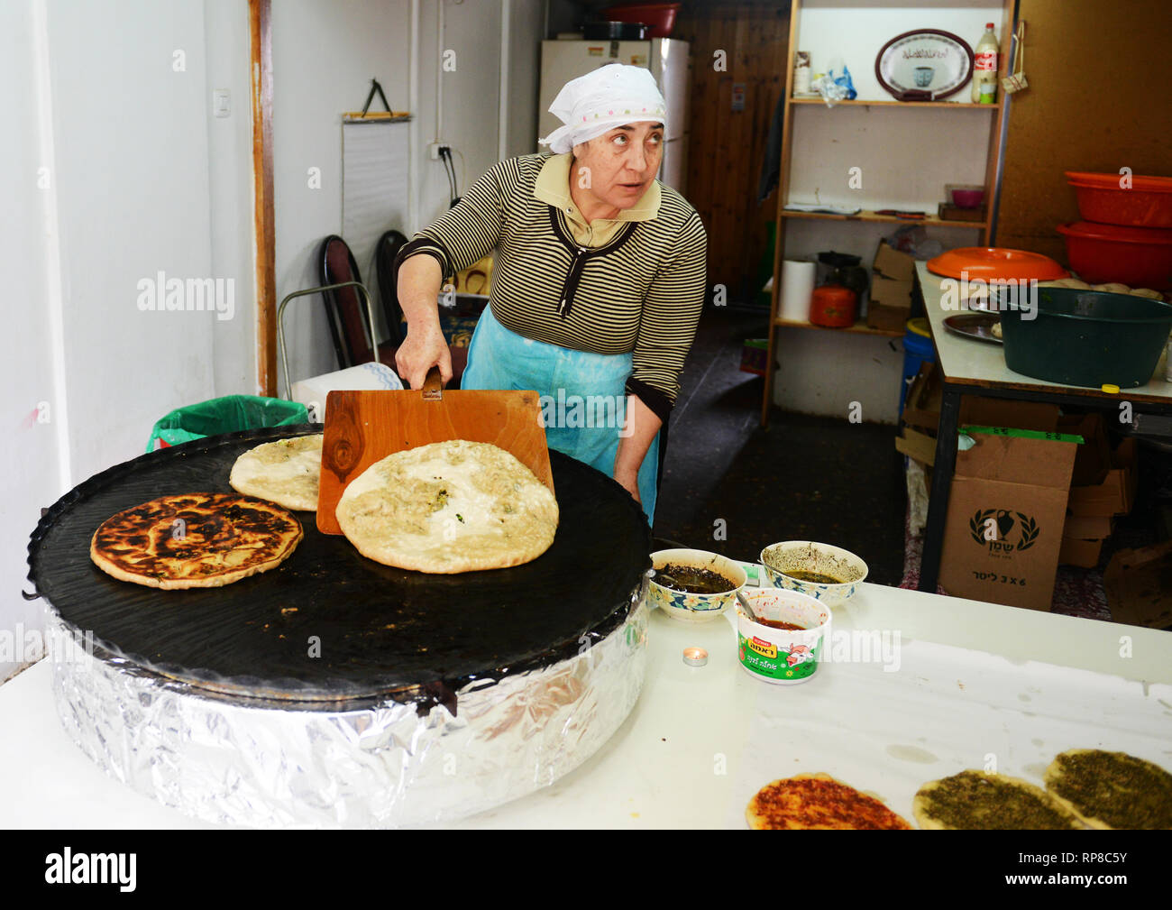 Woman using a dough cutter to divide the naan bread dough into six equal  portions which are flattened and baked. Bakers and pas Stock Photo - Alamy