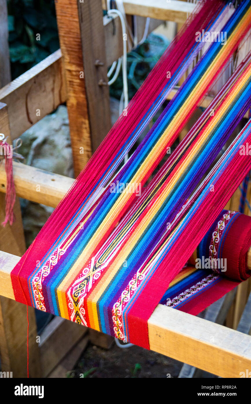 Colorful rainbow alpaca yarn on loom for weaving in Sacred Valley, Cusco Region, Peru. Stock Photo