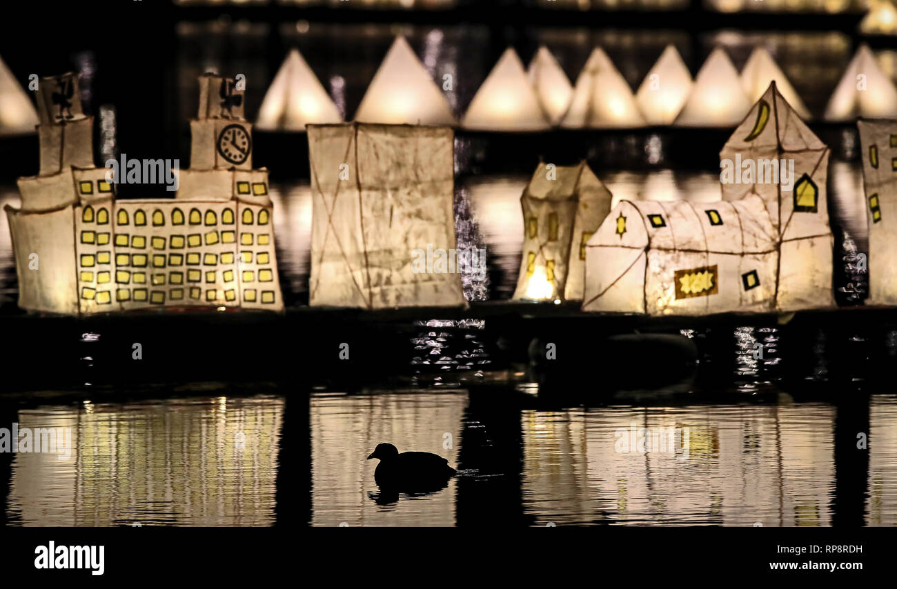 A duck floats past a display of illuminated paper lanterns floating at The Lantern  Company and Writing on the Wall's City of Light, City of Sanctuary public  art project on Sefton Park