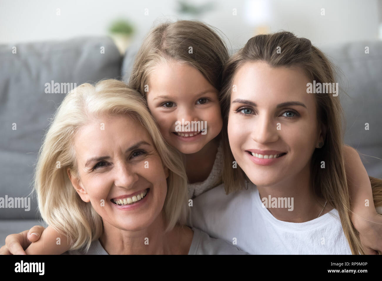 Head shot portrait of smiling grandmother, mother and daughter Stock Photo