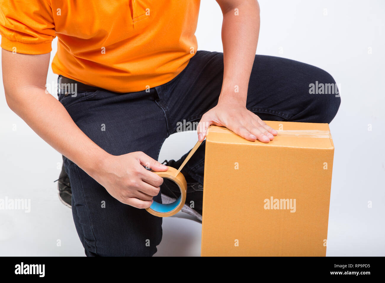 man packing box cardboard package sealing with brown tape move or shipping delivery concept isolated on white background Stock Photo
