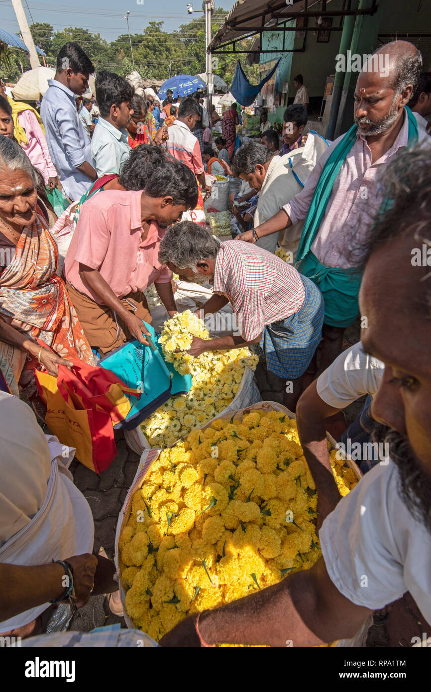 A view showing busy bustling people, locals trading buying selling of flowers at the Madurai flower market in India. Stock Photo
