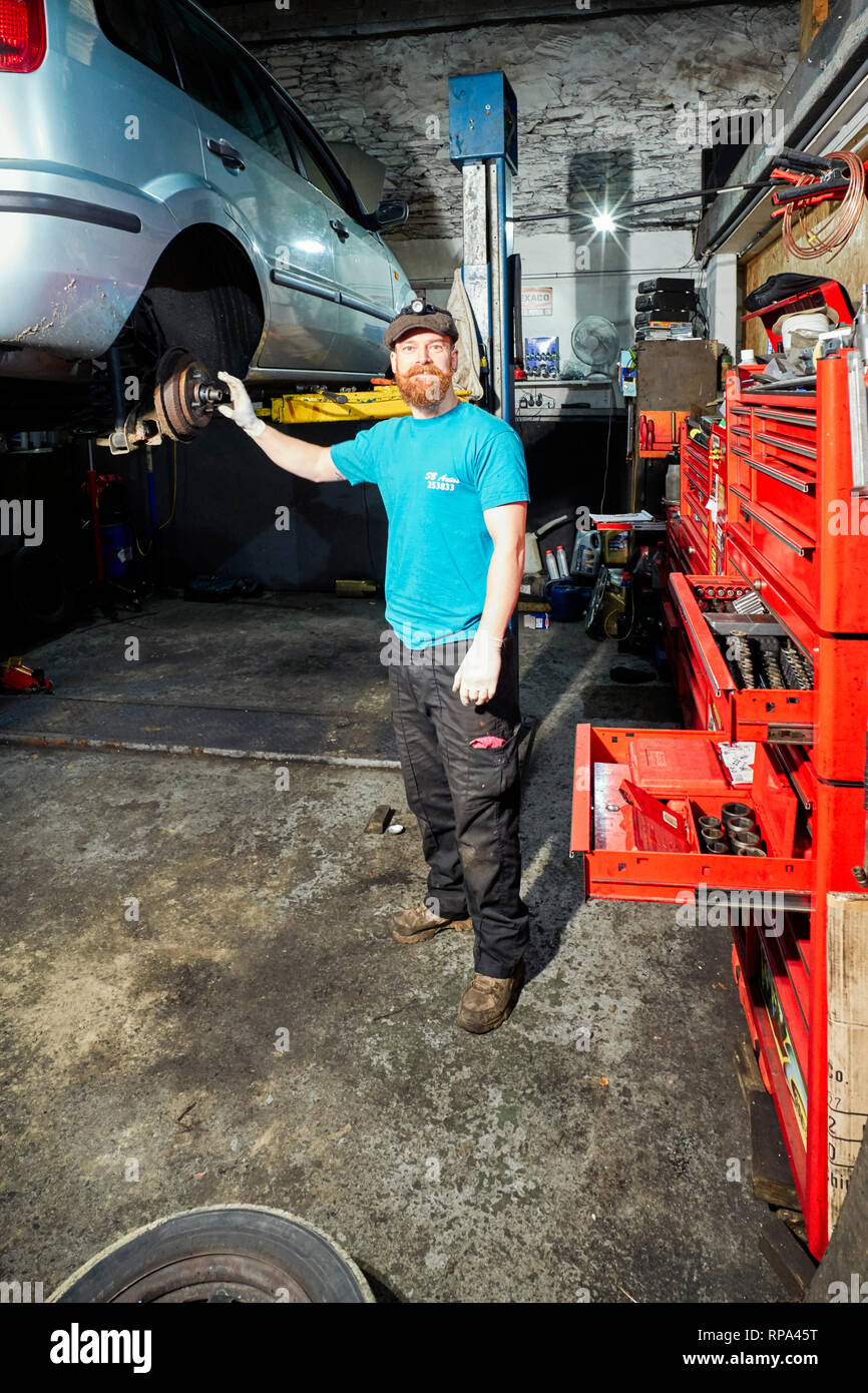 Shaun Booth at SB Autos in Douglas, Isle of Man works on a car in his workshop Stock Photo