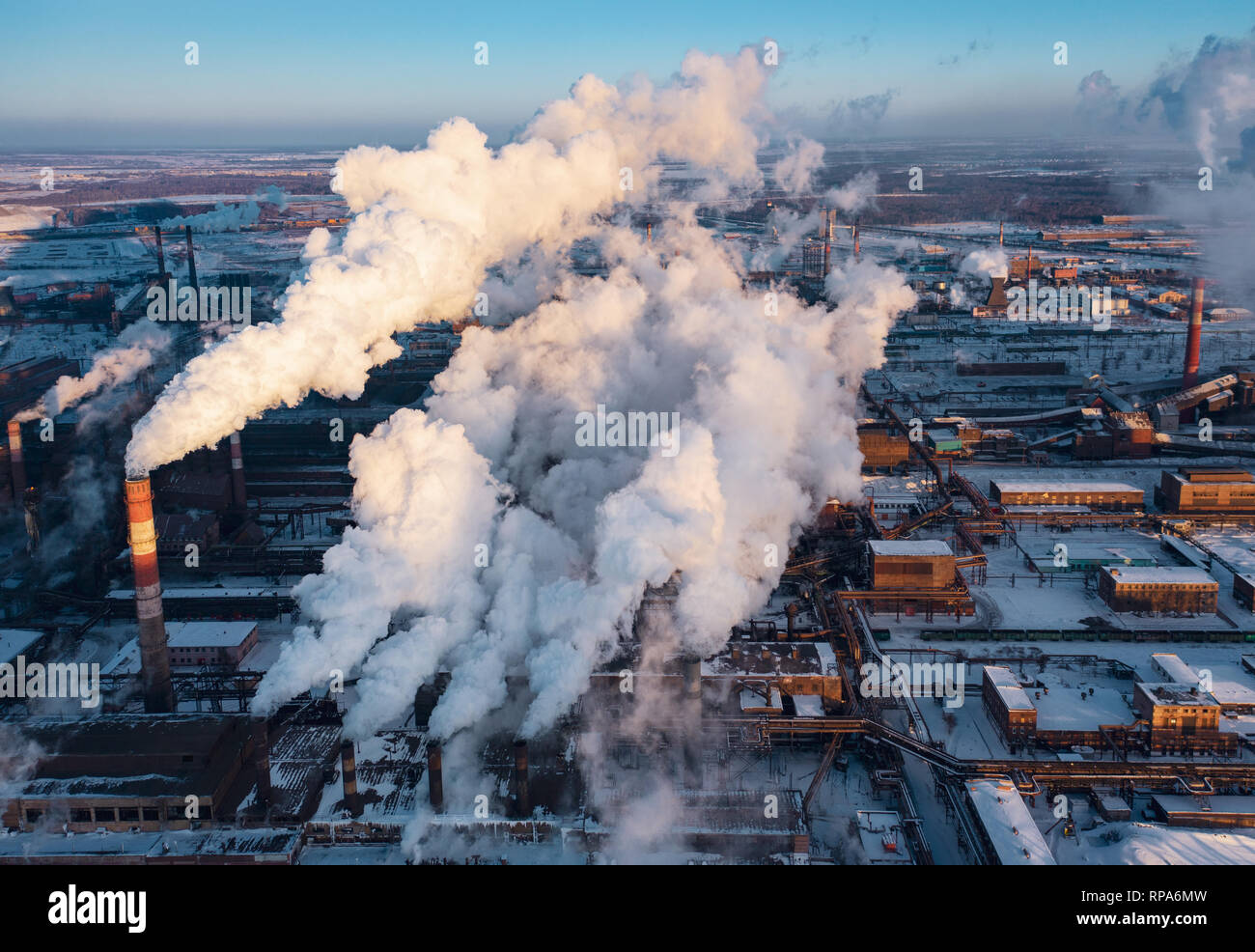 Panoramic view of heavy industry with detrimental impact on nature; CO2 emissions, toxic poisonous gases from chimneys; rusty dirty pipelines and clou Stock Photo