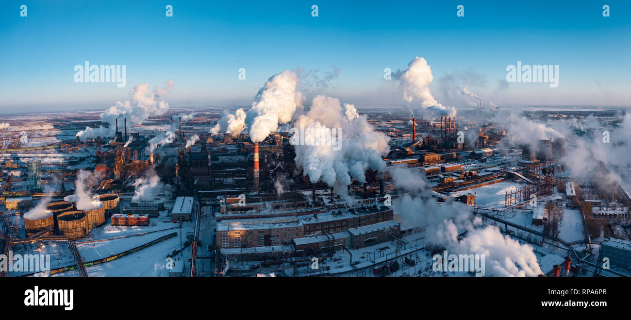 Panoramic view of heavy industry with detrimental impact on nature; CO2 emissions, toxic poisonous gases from chimneys; rusty dirty pipelines and clou Stock Photo