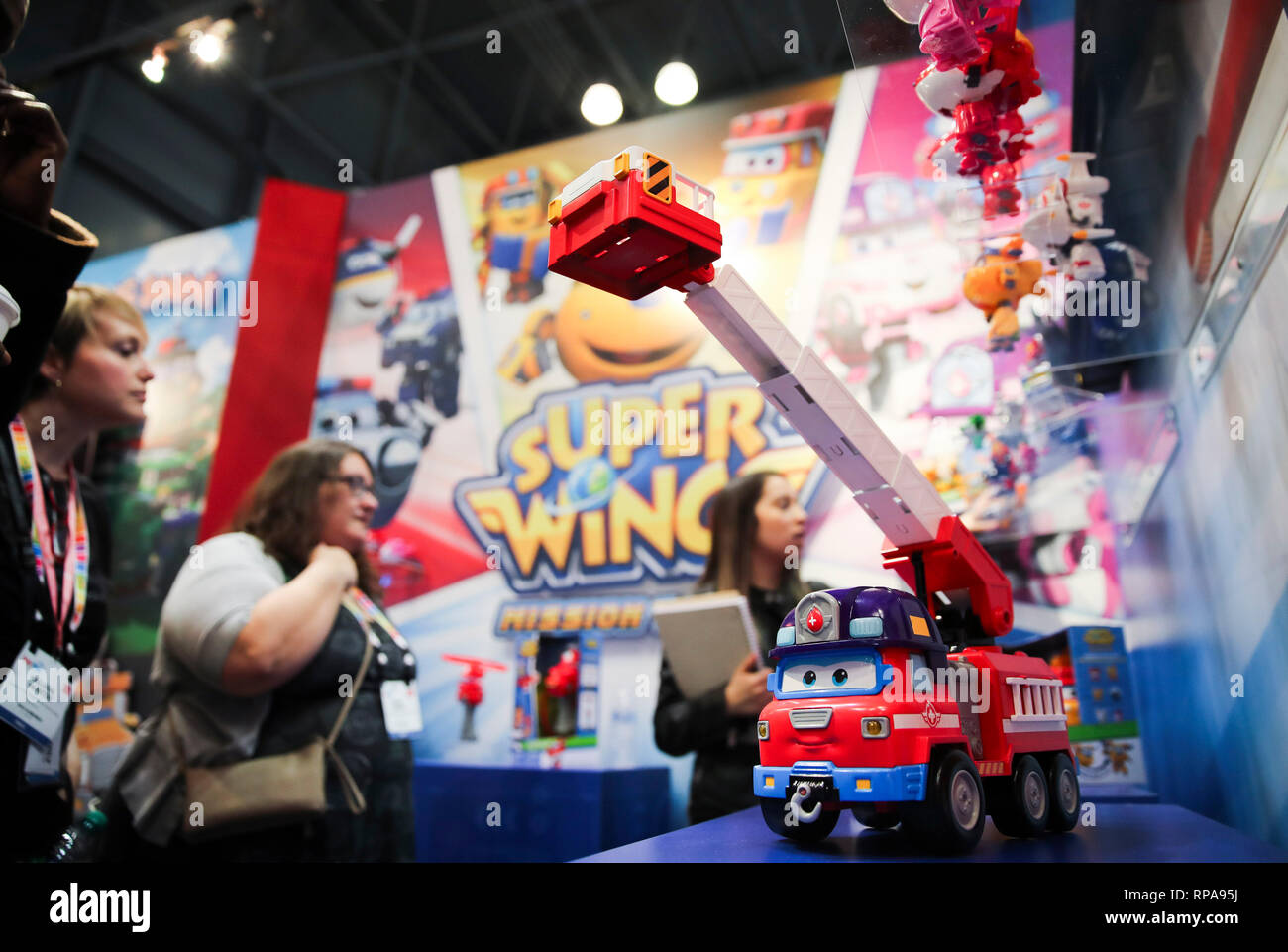 (190221) -- NEW YORK, Feb. 21, 2019 (Xinhua) -- Visitors look at toy products of Super Wings at the booth of Alpha Group Co., Ltd., a major animation, toy and entertainment player from Guangdong Province in southern China, during the 116th Annual North American International Toy Fair at the Jacob K. Javits Convention Center in New York, the United States, Feb. 19, 2019. Chinese toy manufacturers, which produce around 75 percent of global toys each year, are rising up the value chain from the original role as contract manufacturers to designers and makers of their own brands. (Xinhua/Wang Ying) Stock Photo