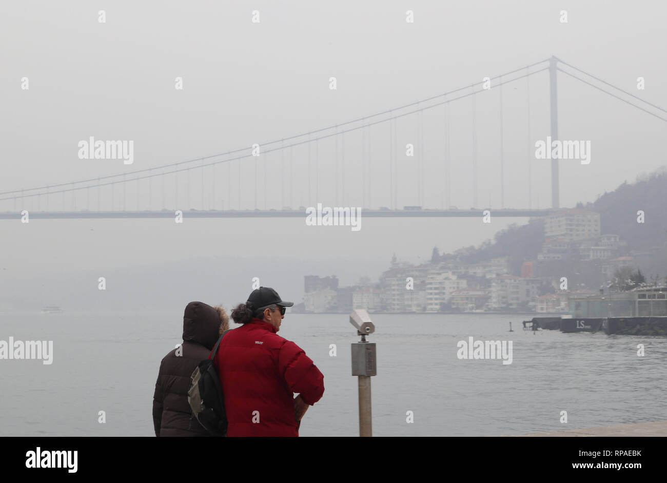 Istanbul, Turkey. 21st Feb, 2019. People stand by the Bosphorus strait amid heavy fog in Istanbul, Turkey, Feb. 21, 2019. Heavy fog hit Turkey's largest city Istanbul on Thursday, causing hundreds of flights and ferries to be canceled or delayed. Credit: Xu Suhui/Xinhua/Alamy Live News Stock Photo