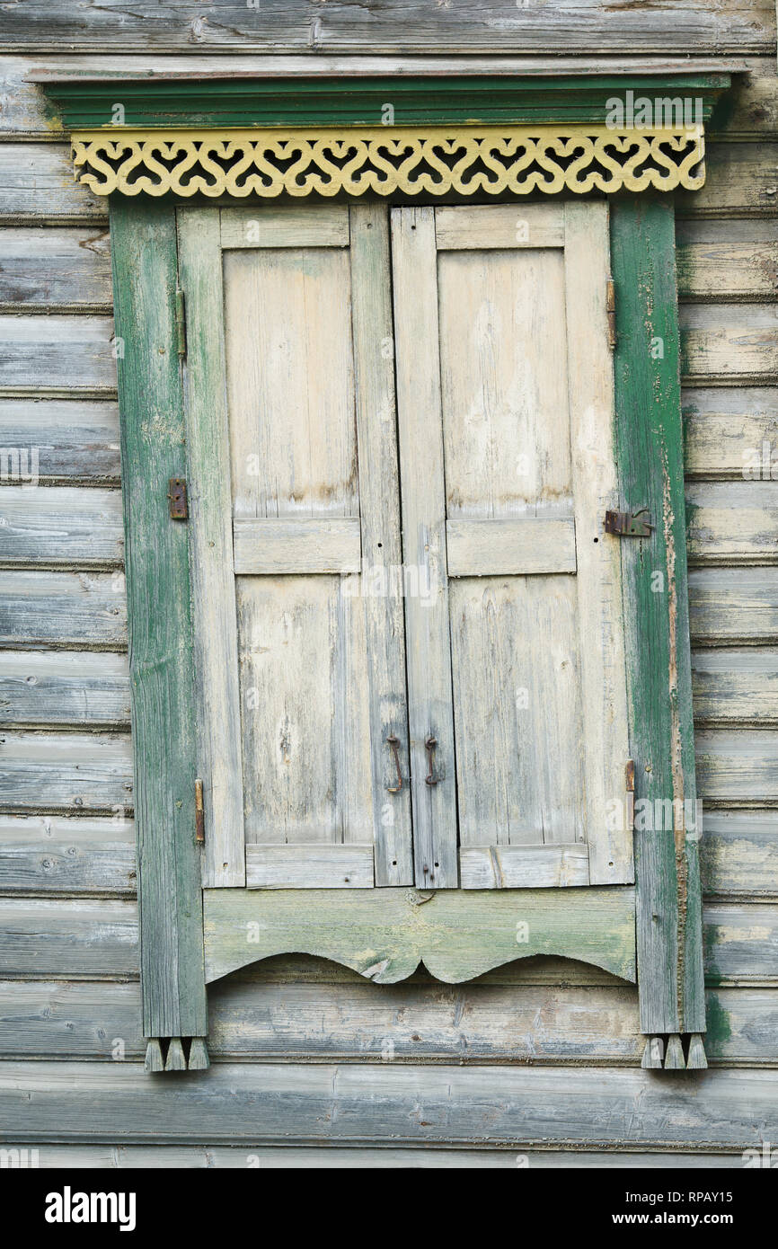 The window of the old house is covered with wooden shutters Stock Photo