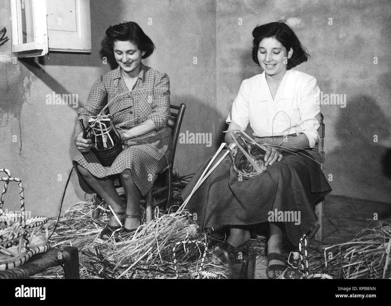women covering with straw glass objects, empoly, italy, 1952 Stock Photo