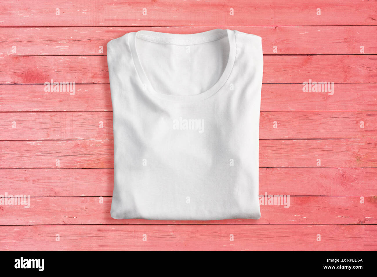 White folded t-shirt on pink background Stock Photo