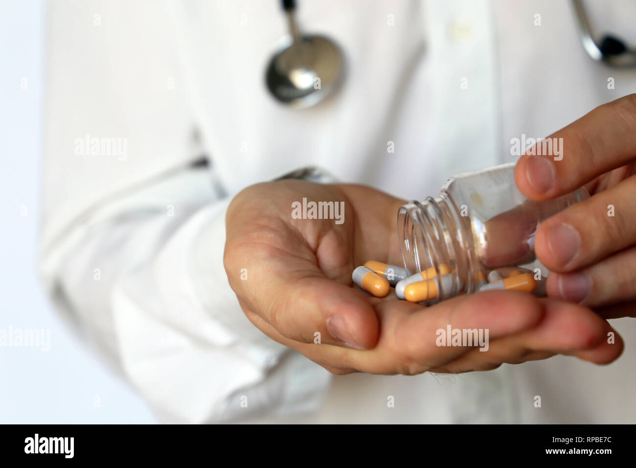 Doctor with bottle of pills, man giving medication in capsules. Concept of medical exam, dose of drugs, vitamins, medical prescription, pharmacy Stock Photo