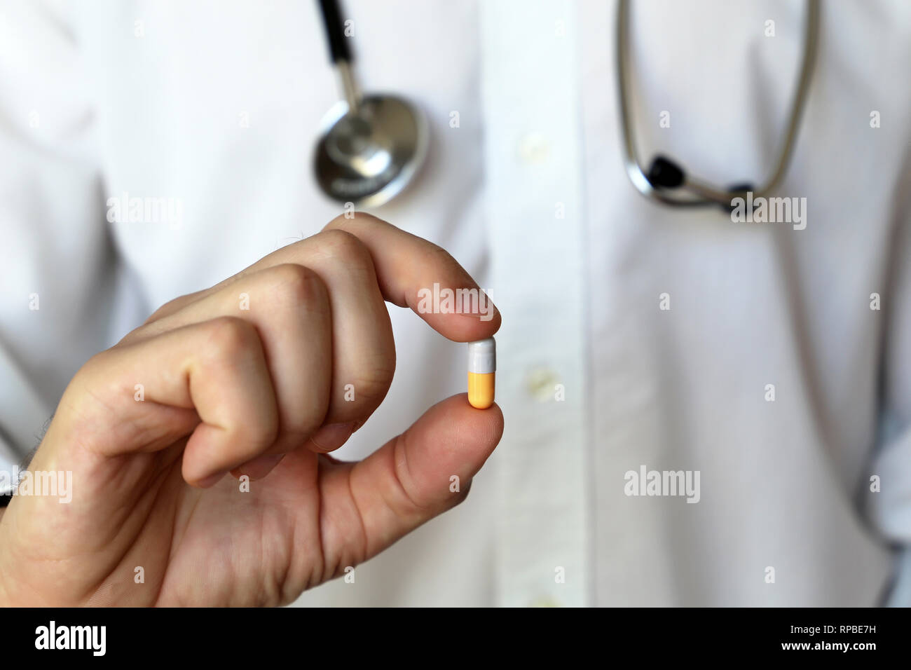 Doctor with pill, medication in capsule in male hand. Concept of medical exam, pharmacist, vitamins, prescription, health care Stock Photo