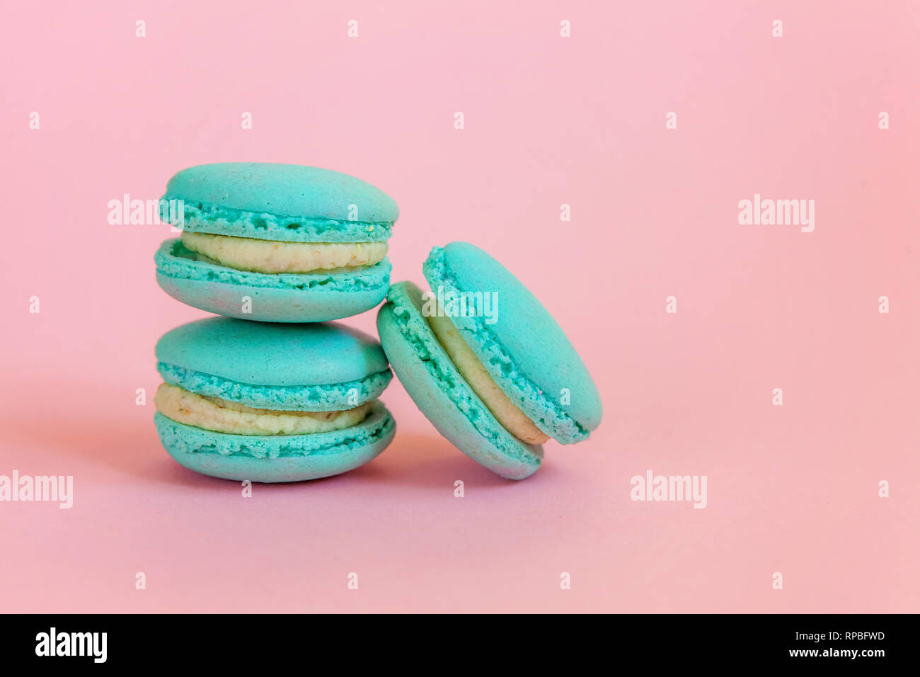 Sweet almond colorful unicorn blue macaron or macaroon dessert cake isolated on trendy pink pastel background. French sweet cookie. Minimal food baker Stock Photo