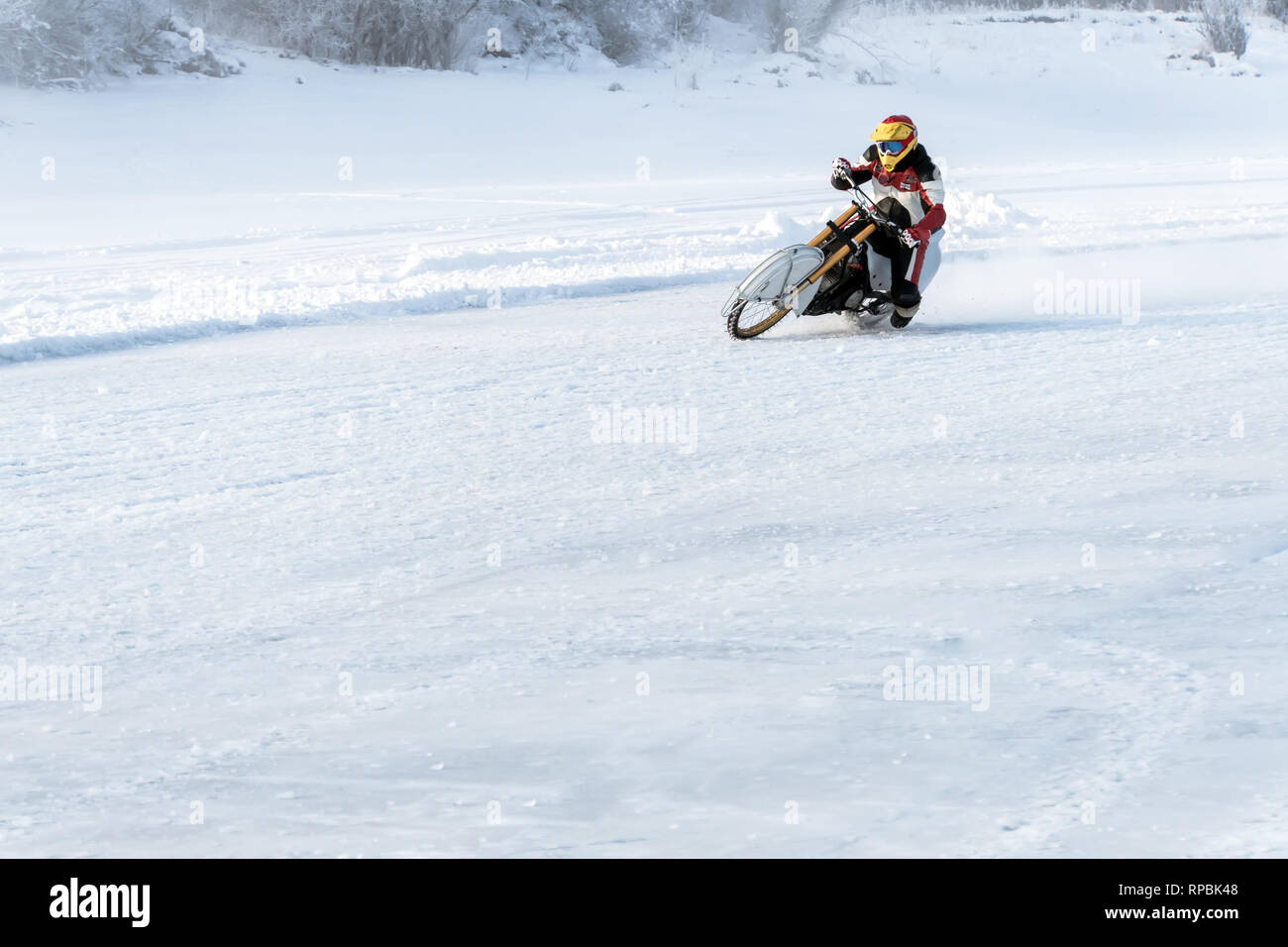 Motorcycle unmarked winter motocross track throws your bike when entering in dangerous turn. winter Speedway. Pursuit Stock Photo