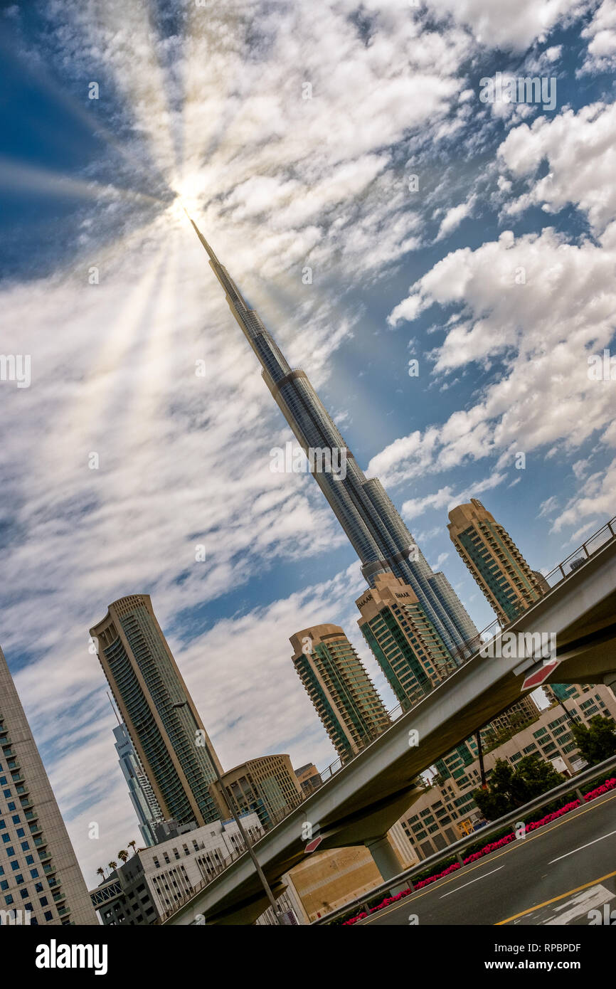 Feb 11, 2019 - Duabi UAE: Burj Khalifa touching the Sun on partly cloudy day Stock Photo