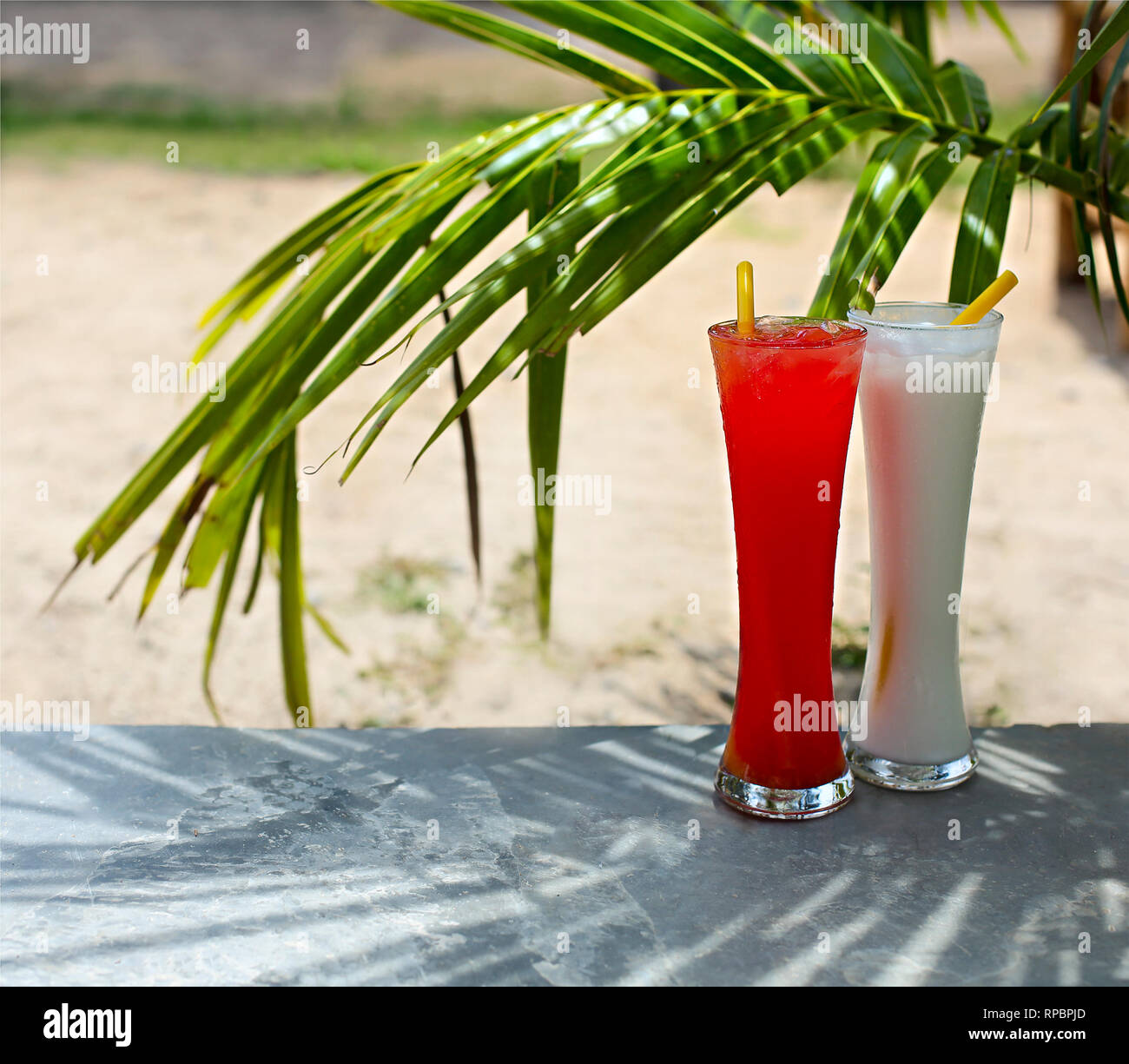 Tequila sunrise and pina colada cocktails under the palm outdoors Stock Photo Alamy