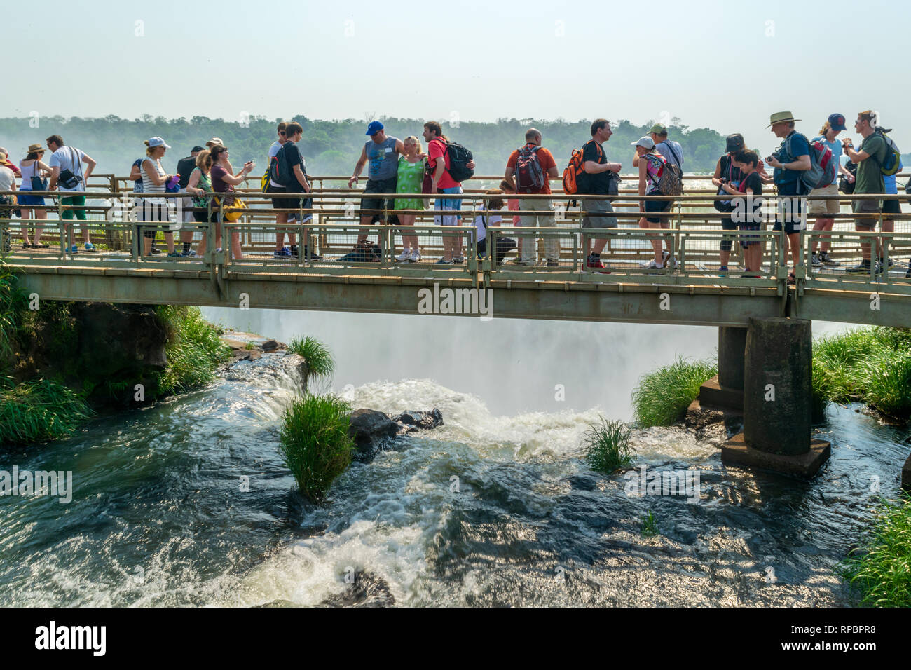 PUERTO IGUAZU, MISIONES, ARGENTINA - SEPTEMBER 17, 2015: Tourists on a walkway overlooking the Devil's Throat fall in Iguazu National Park Stock Photo