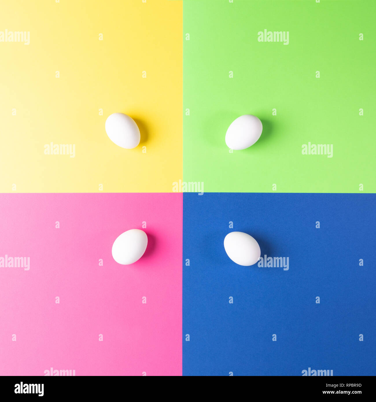 Four white eggs on colorful four-color background. Easter pop art pattern.  Stock Photo