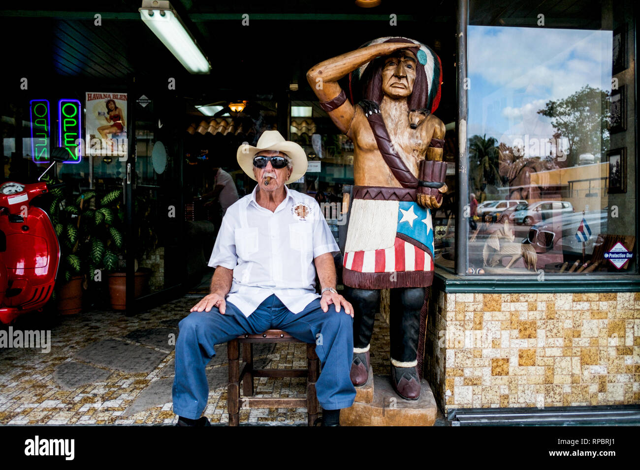 A cigar smoking man sitting at the entrance of a cigar shop in the Little Havana neighborhood, Miami. (Photo credit: Gonzales Photo - Flemming Bo Jensen). Stock Photo