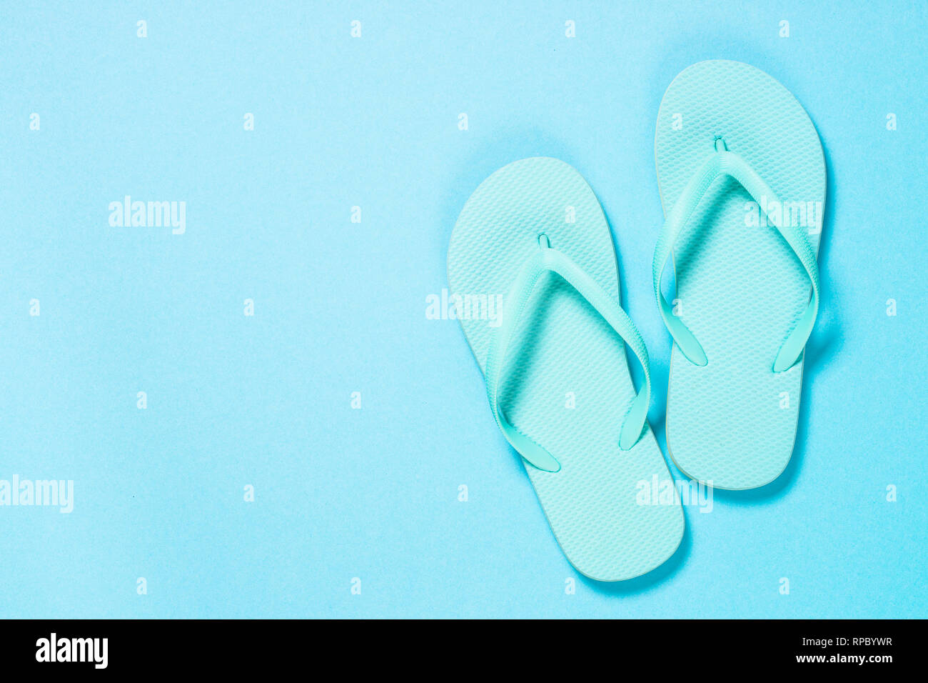 Blue flip flops on blue background Stock Photo - Alamy