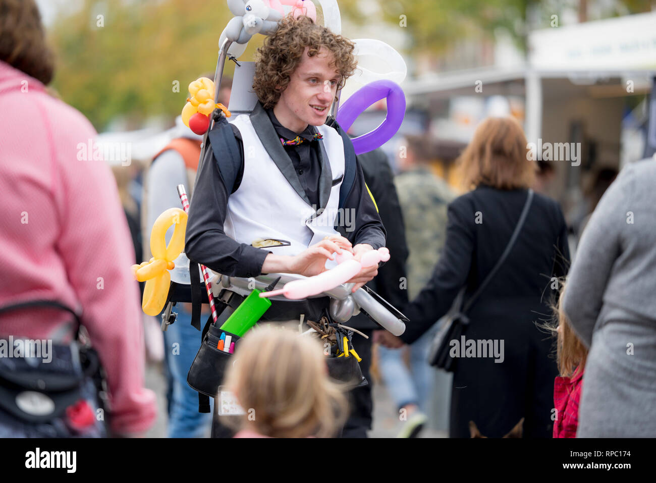 Balloon artist walking around on the Saturday morning market of Groningen  in The Netherlands offering to make figures and animals out of balloons  Stock Photo - Alamy